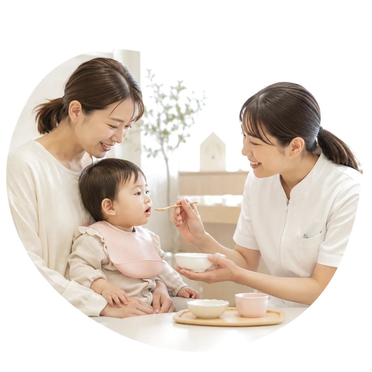 離乳食教室 母子と歯科衛生士がスプーンで食事を教える様子